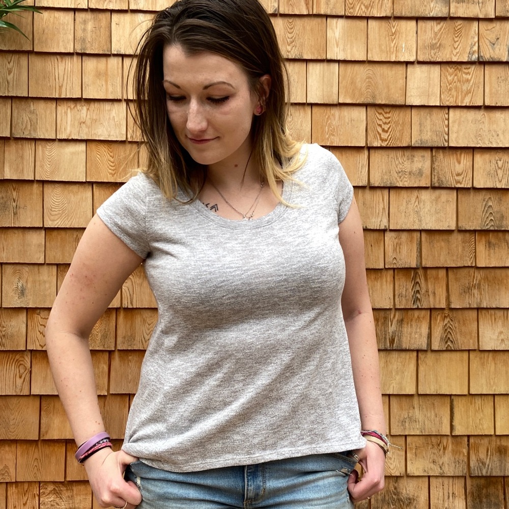Loosely fitted grey tee shirt.
